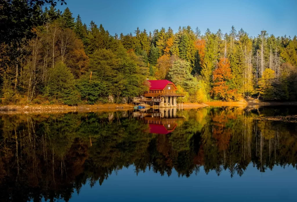 The Red Lake, Surrounded by Forested Hills and Reflections of the Trees